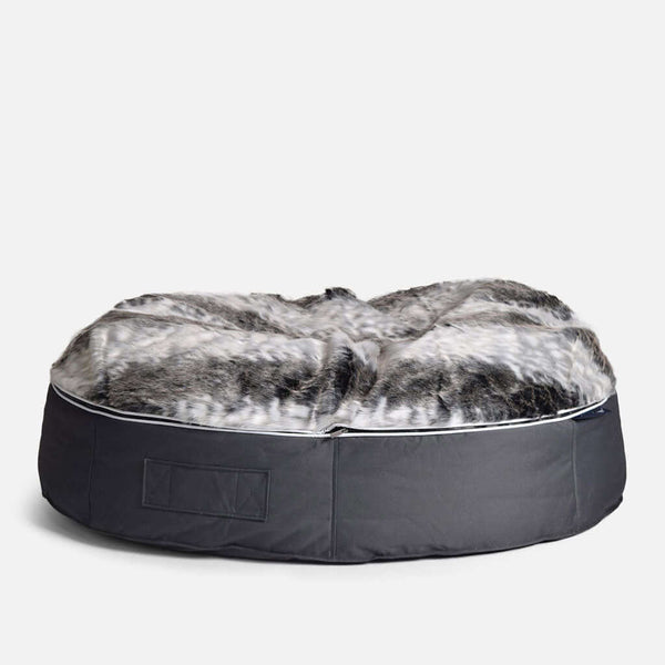 En rund, plyschig hundeseng XL från Ambient Lounge har en mjuk, grå topp i fuskpäls och mörkgrå tygsidor, placerad på en vit bakgrund.