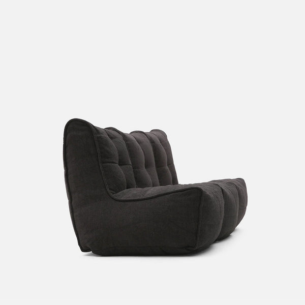 En plyschig, mörkgrå Mod 3 Movie Couch från myke møbler visas i profil mot en vanlig vit bakgrund, med en lågprofilerad, armlös design med tuftad, stoppad klädsel för en elegant modulær sofflook.
