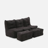 En modern, mörkgrå Mod 3 Movie Couch tresitssoffa med tuftad design, tillsammans med två matchande rektangulära ottomaner, mot en vit bakgrund.