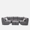 En modern grå modulær soffa med tuftade kuddar, två matchande ottomaner och två accentkuddar, placerade i en U-form mot en vit bakgrund - en perfekt modern stueløsning från Ambient Lounge.