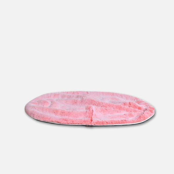 En rund, platt, rosa pälsmatta med mjuk textur och en luksuriøs pelstopp, placerad på en vit bakgrund.