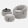 En modern fåtölj i ljusgrått tyg från Contempo Indoor Package med en matchande ottoman och ett litet runt sidobord med en surfplatta, allt mot en vit bakgrund.